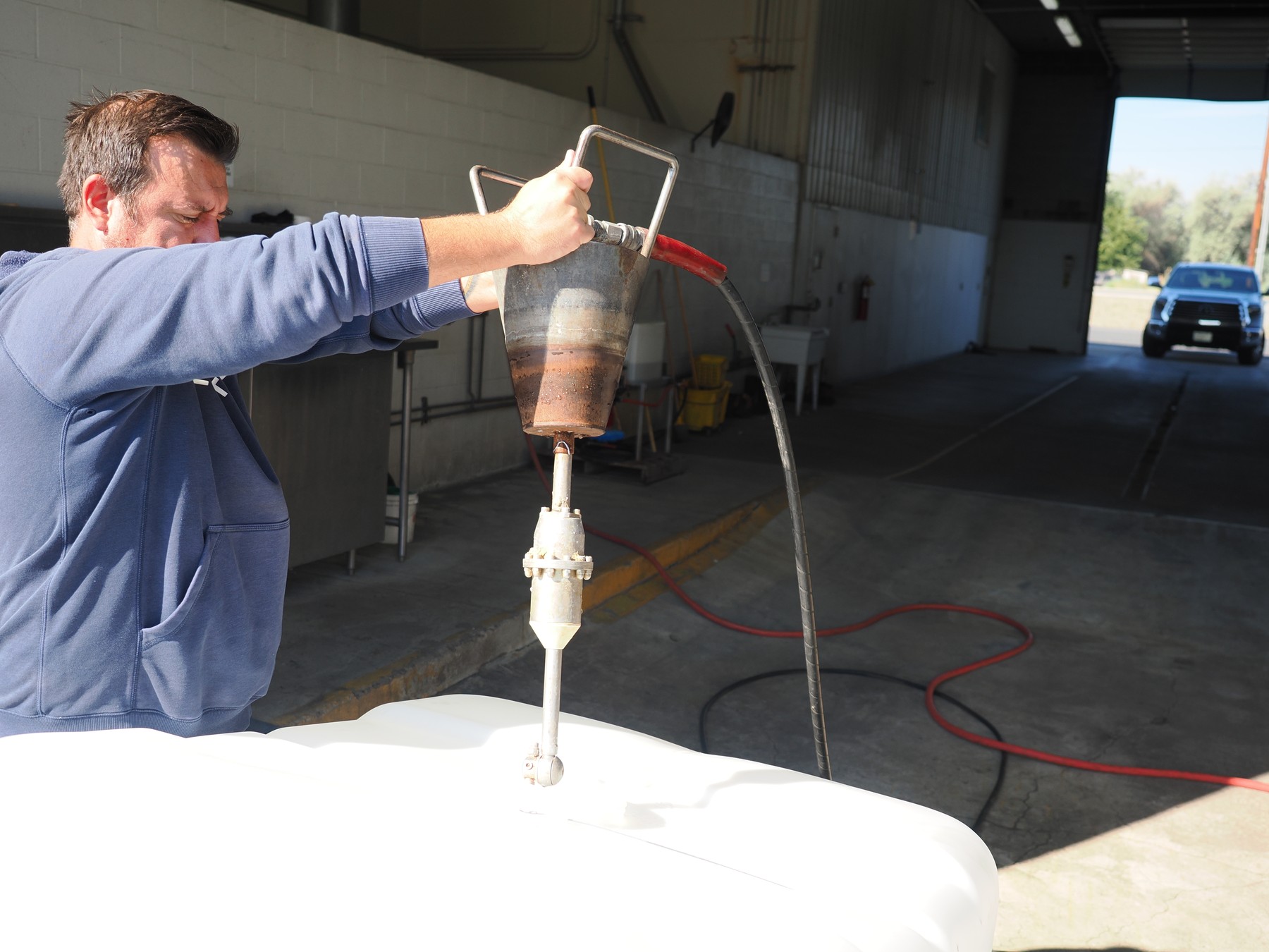 Clean Tank employee positioning an internal IBC bottle-washing spinner