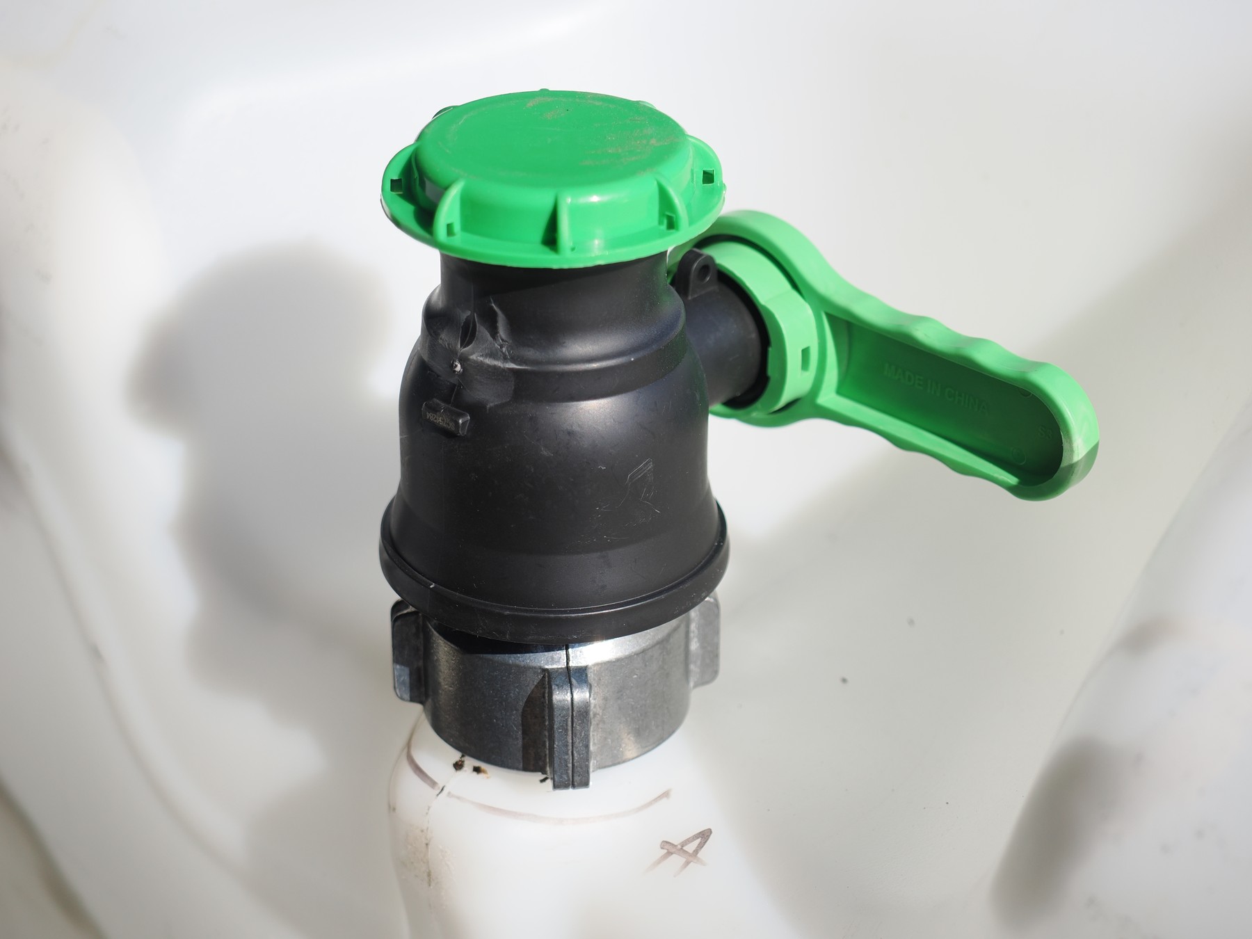 Pesticide IBC discharge valve fitted with a green check-valve closure and handle