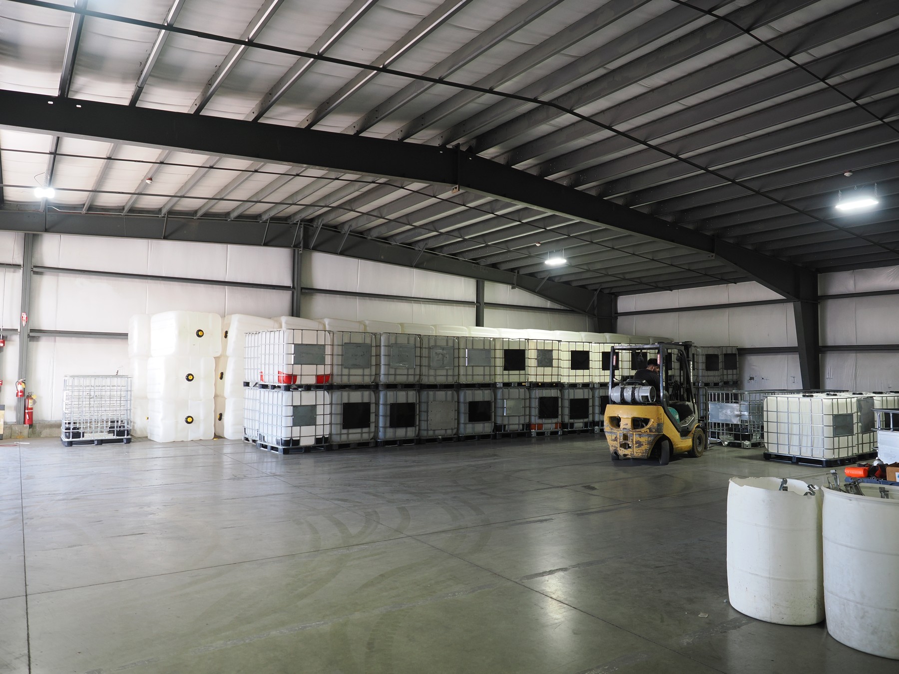Clean Tank warehouse with staged IBC bottles, assembled containers and a forklift in operation